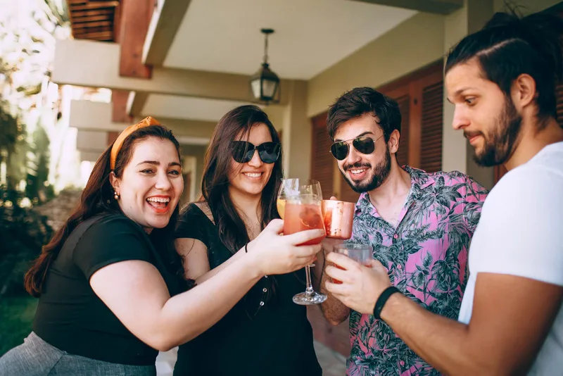 Group of friends toasting with drinks outdoors at a celebration