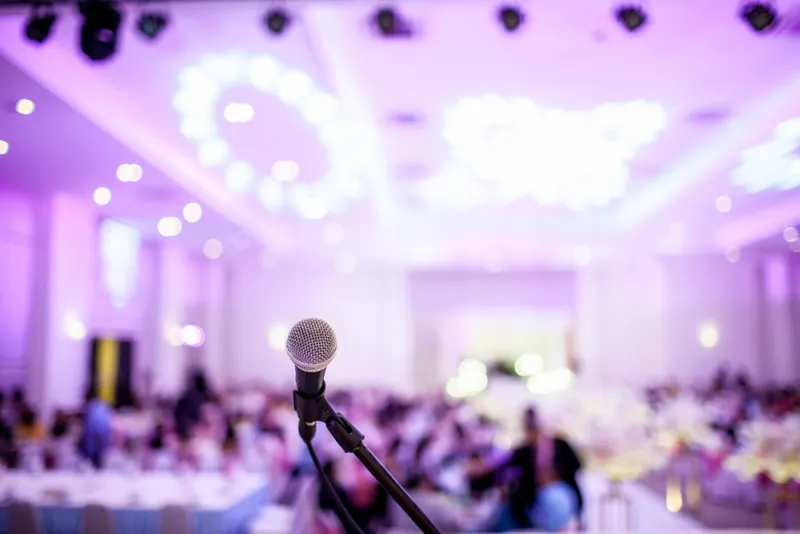 Microphone in front of a festively lit wedding banquet hall