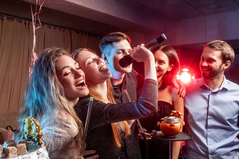 Friends singing karaoke together at a private party