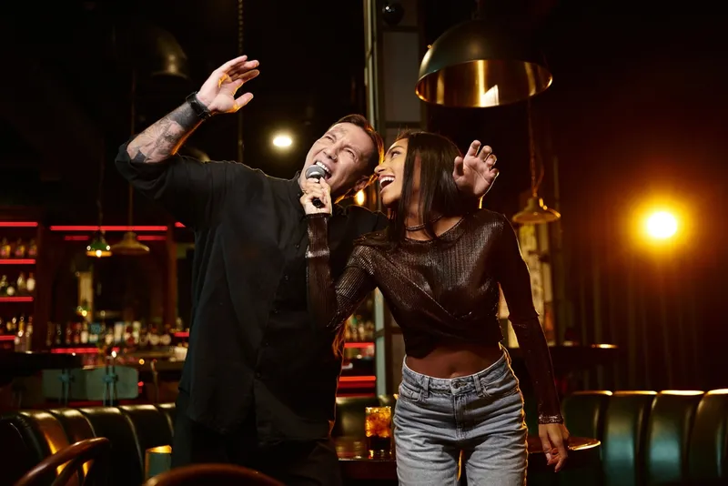 Two people singing karaoke together in a bar